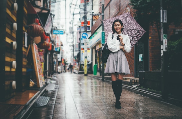 Photo full length of young woman standing on road in city