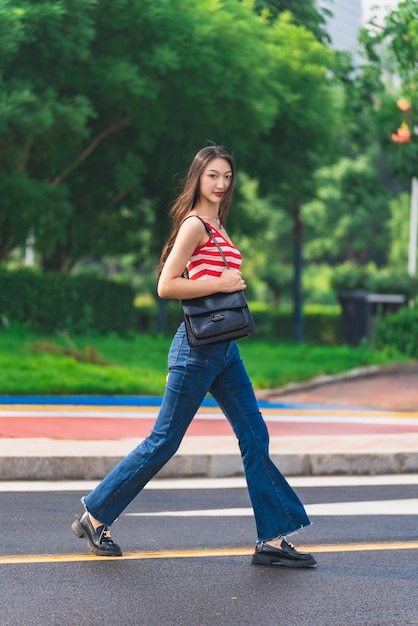 道路に立っている若い女性の全長