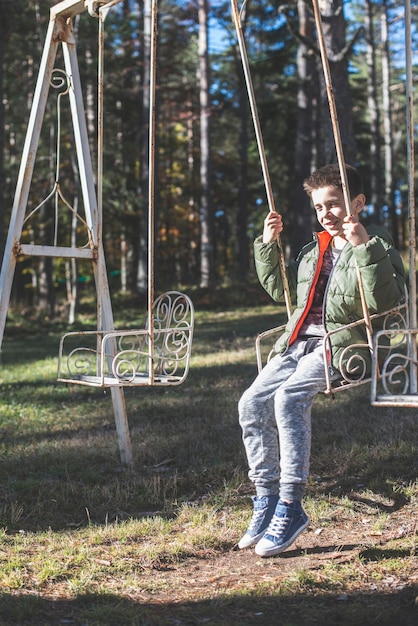 Photo full length of young woman standing on swing in playground