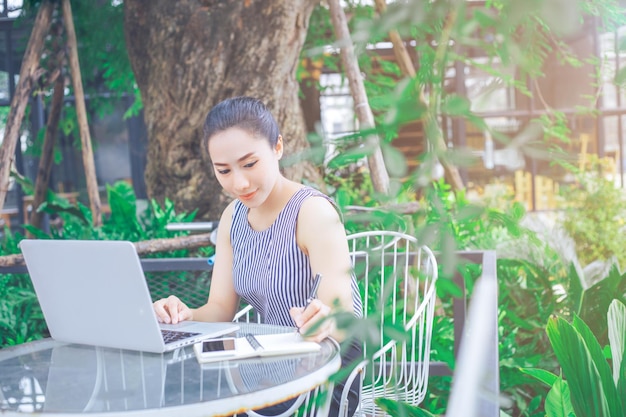 外で携帯電話を使っている若い女性の全長