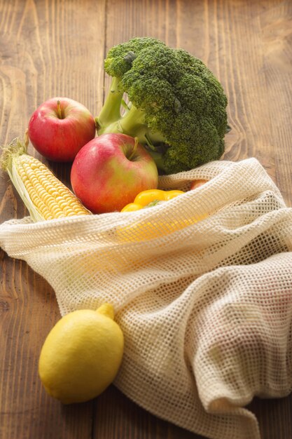 Full mesh bag of different health food on wooden table. Clean or eco eating concept