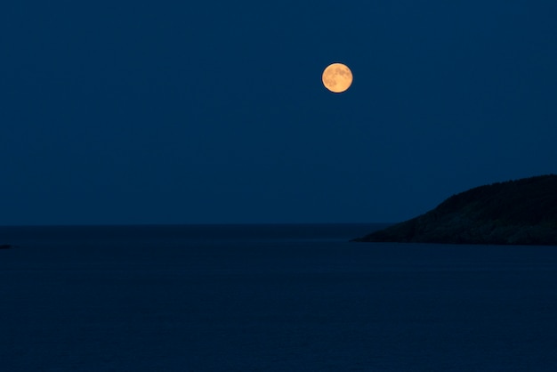Full moon over the ocean at night, calvert, avalon peninsula,\
newfoundland and labrador, canada