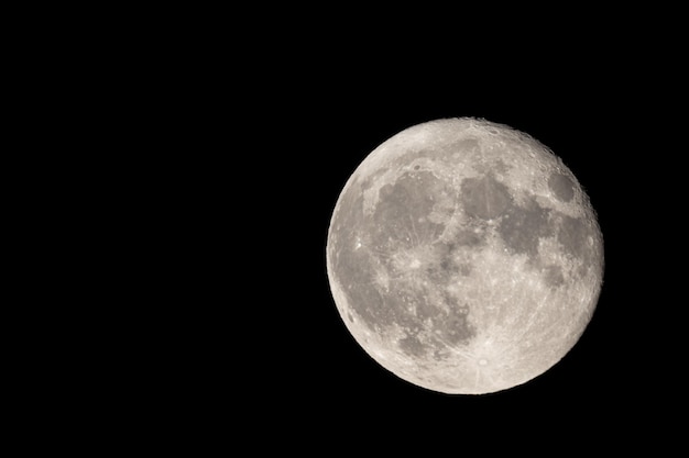 full moon photographed with a telescope and reflex camera where are visible craters on the surface