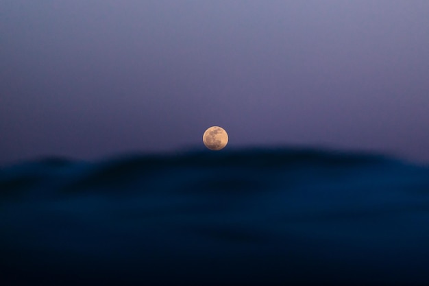 Photo full moon over the sea waves on the beach