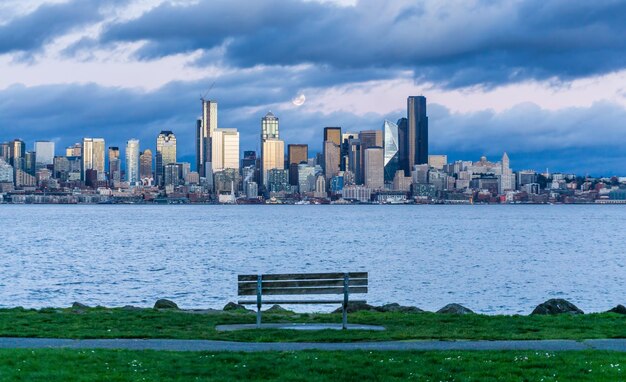 Photo a full moon shines above the seattle skyline