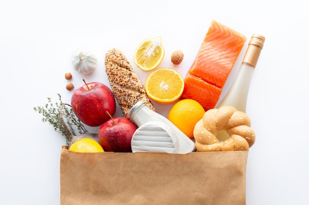 Full paper bag of various healthy food.Healthy food background.Healthy food in fruits and vegetables in a paper bag.nutrition.Shopping food supermarket concept.Wine, cheese and fruit.Shopping