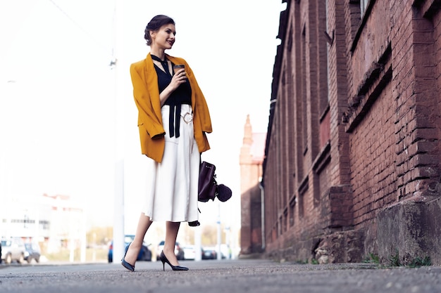 Full photo of stylish happy young business woman walking on the street