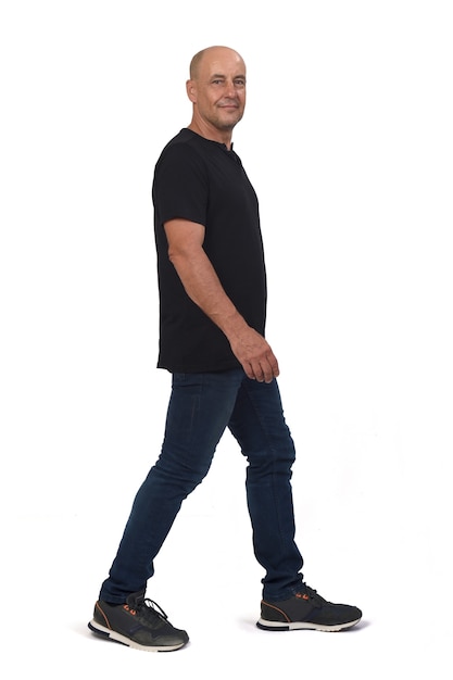 Full portrait of a bald man walking on white background, side view