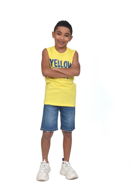 Full portrait of a boy dressed in shorts and sleeveless with arms crossed on white background