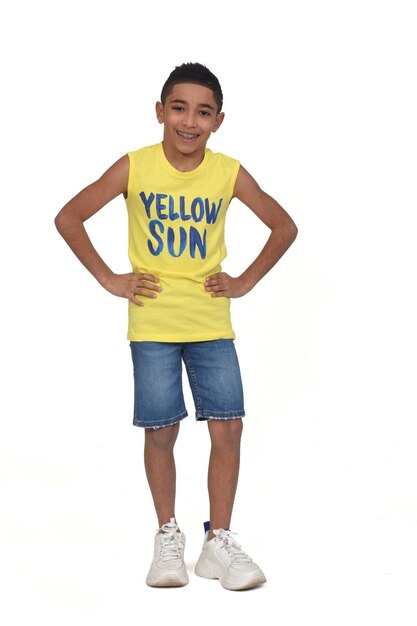 Full portrait of a boy dressed in shorts and sleeveless with hands on hip on white background