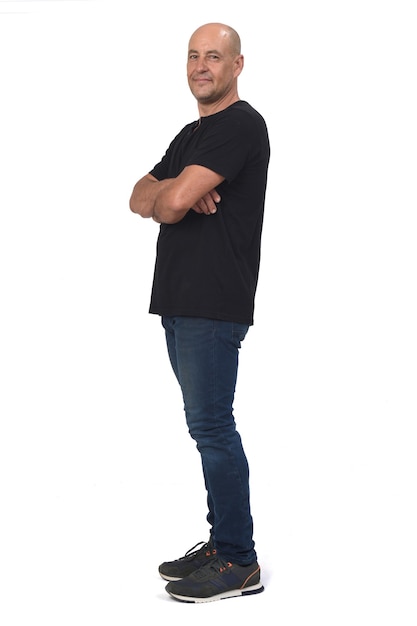 Photo full portrait of a man side view and looking at camera, arms crossed on white space