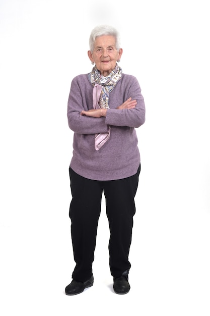 Полный портрет пожилой женщины со скрещенными руками на белом фоне