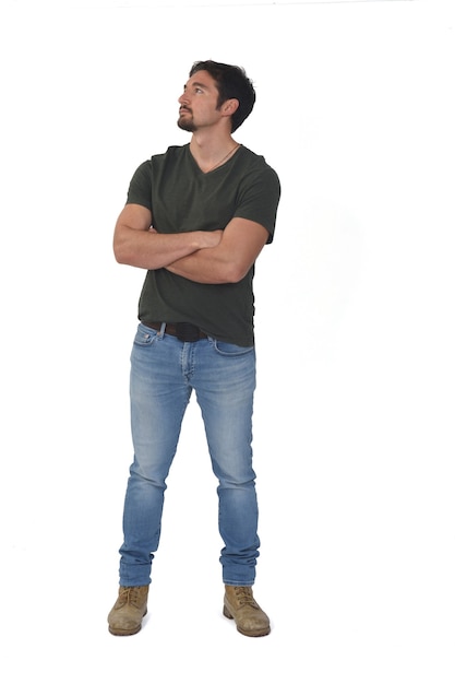 Photo full potrait of a man looking up and arms crossed on white background