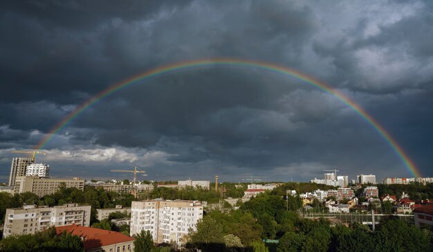 Full rainbow above Lvov city in Ukraine with cloudy dark sky