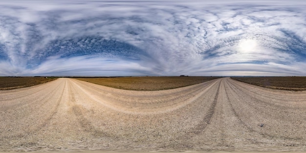 Full seamless spherical hdr panorama 360 degrees angle view on no traffic gravel road among fields in spring day with awesome clouds in equirectangular projection for VR AR virtual reality content