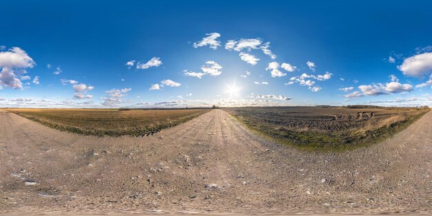 Full seamless spherical hdri panorama 360 degrees angle view on gravel road among fields in spring day with awesome clouds in equirectangular projection ready for vr ar virtual reality content