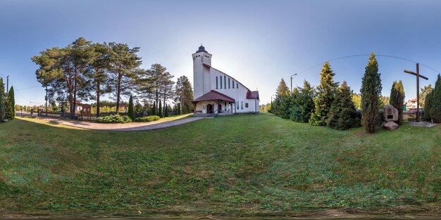 Полная бесшовная сферическая панорама hdri с углом обзора 360 градусов возле неоготической католической церкви в маленькой деревне в равнопромежуточной проекции с зенитом и надиром AR VR