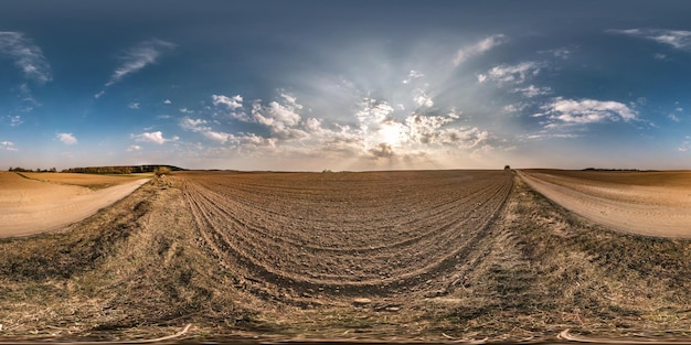 写真 正距円筒図法vrarバーチャルリアリティコンテンツの素晴らしい雲と春の夕方の日没の牧草地のフィールド間の砂利道の近くの完全なシームレスな球形のパノラマ360度の角度のビュー