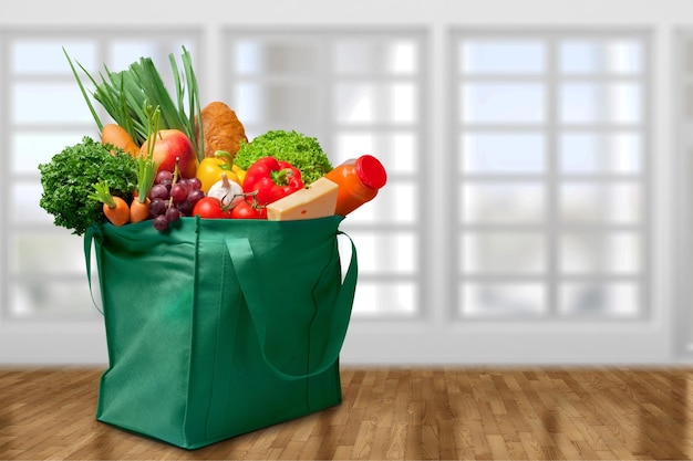 Full shopping bag on kitchen background