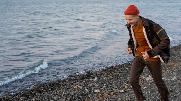 写真 海辺で走っているフルショットの少年