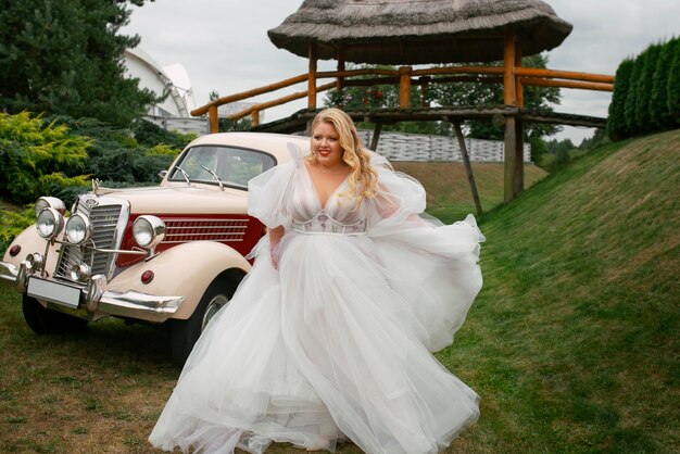 Foto sposa a tutto campo in posa con auto d'epoca