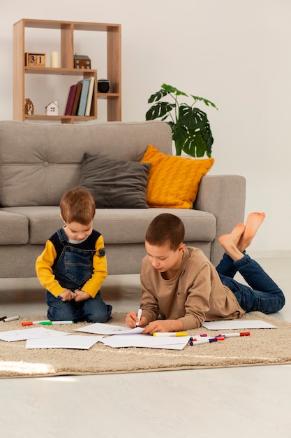 Full shot brothers drawing at home