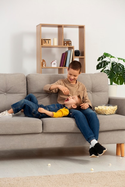 Photo full shot brothers eating popcorn