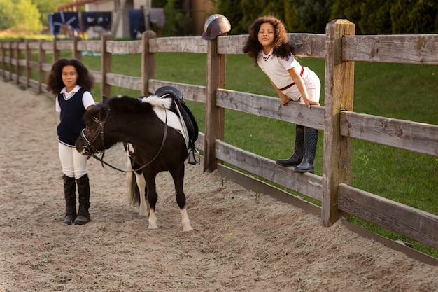 写真 乗馬を学ぶ子供たちのフルショット