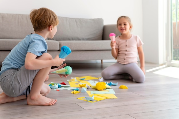 紙で遊ぶフルショットの子供たち