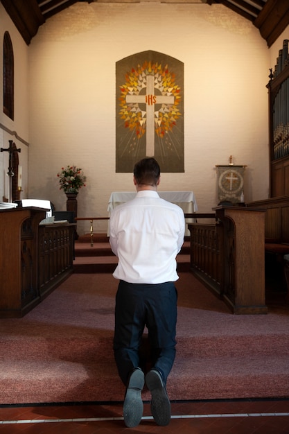 写真 フルショットのキリスト教徒の男性が祈っています