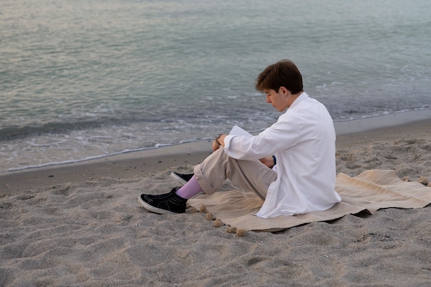 海辺のフルショットの瞑想的な男性