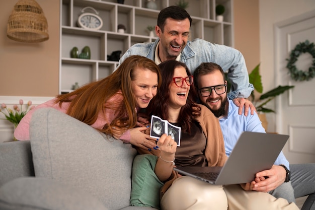 Full shot couple announcing pregnancy with laptop