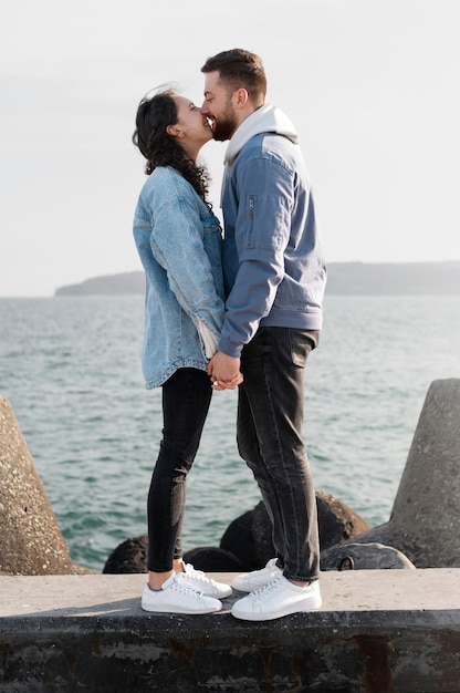 写真 海辺でキスするフルショットのカップル