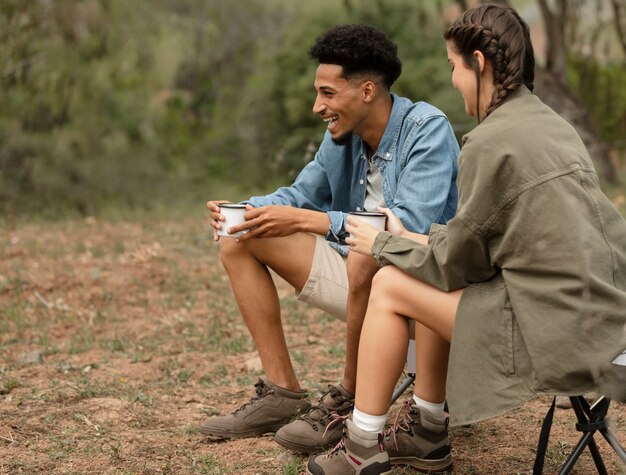 Full shot couple sitting outdoors