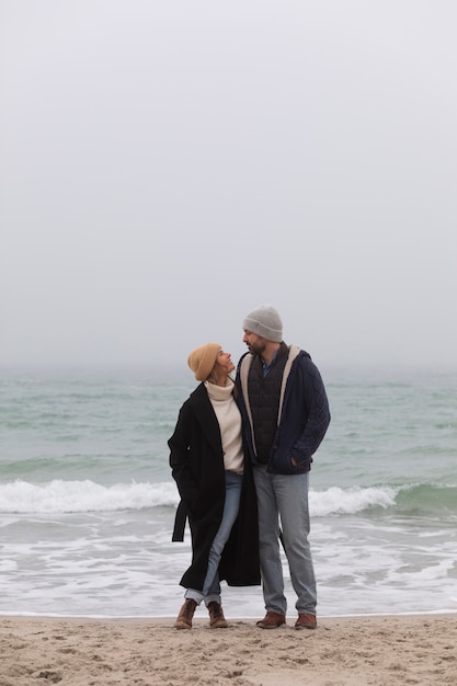 Full shot couple spending time at seaside