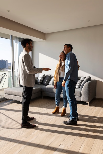 Full shot couple talking to real estate agent