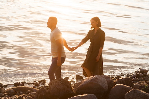 Full shot couple walking on shore