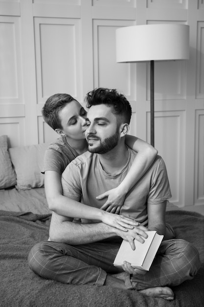 Full shot couple with book in bed