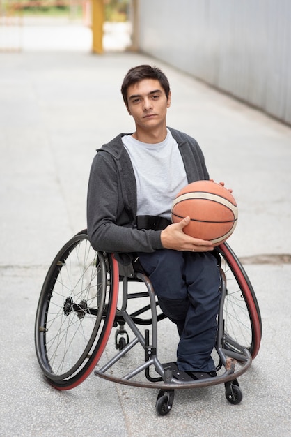 Full shot disabled man holding basketball