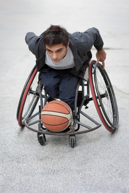 Foto uomo disabile del colpo pieno che gioca con la palla