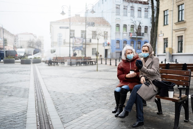 写真 ベンチに座っているフルショットの年配の女性