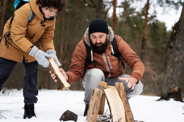 Full shot familie hout voorbereiden op vuur