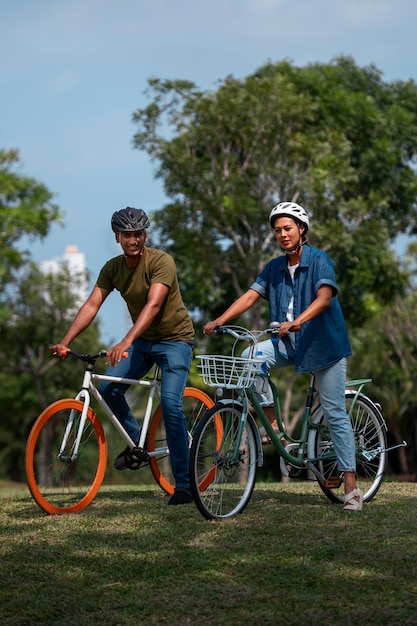 Foto famiglia a tutto campo in bicicletta all'aperto