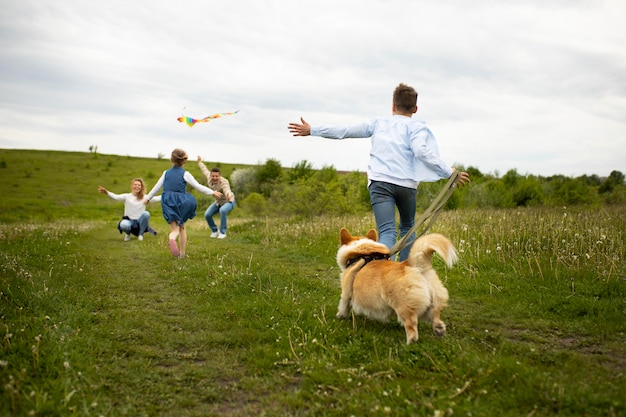 Full shot family playing with dog