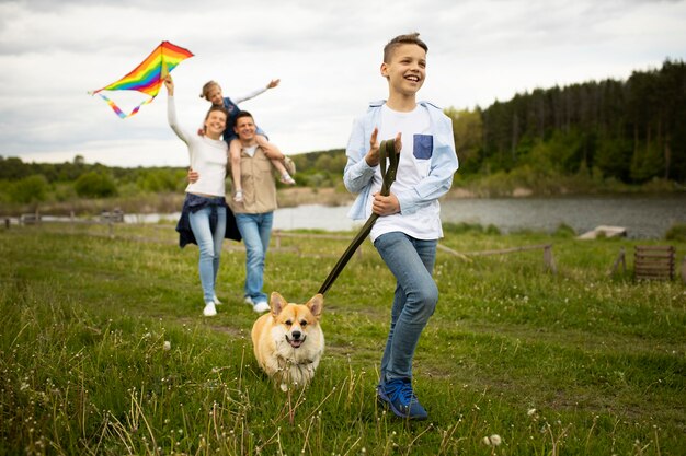 Foto famiglia a tutto campo che gioca con l'aquilone all'esterno