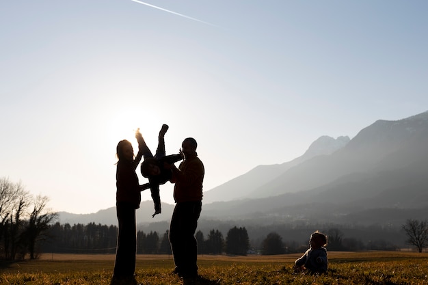 Full shot family silhouette in nature