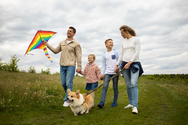 Photo full shot family with kite and cute dog