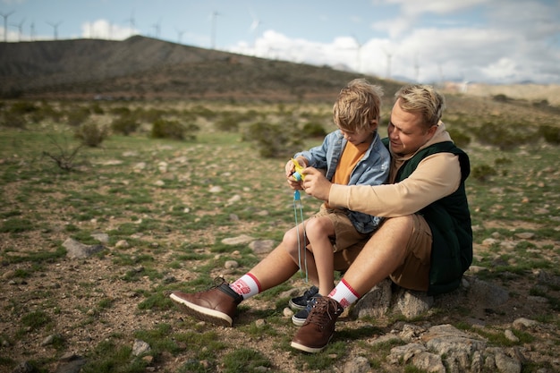 Full shot father holding kid in american desert