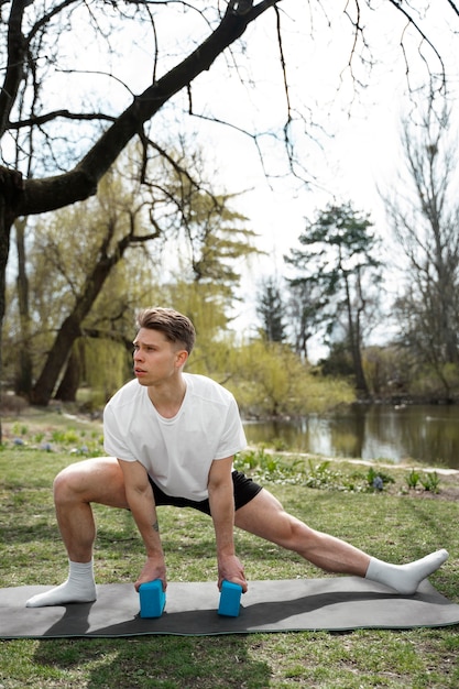 Photo full shot fit man stretching with yoga blocks