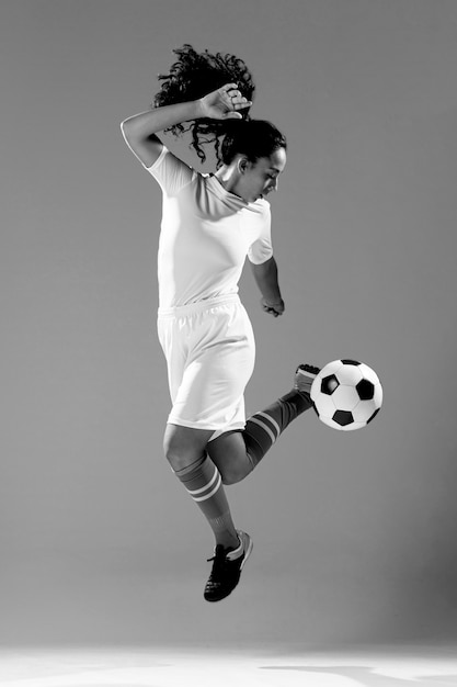 サッカーボールで遊ぶ女性に合う完全なショット